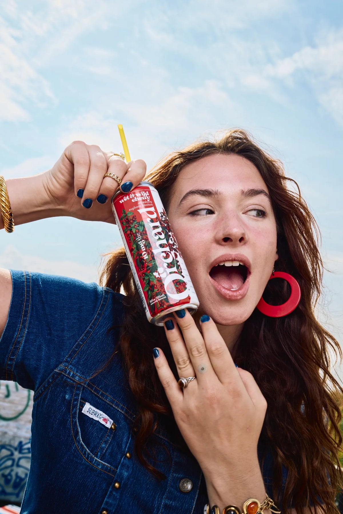 woman holding a Wet & Wild Cherry can up to her face